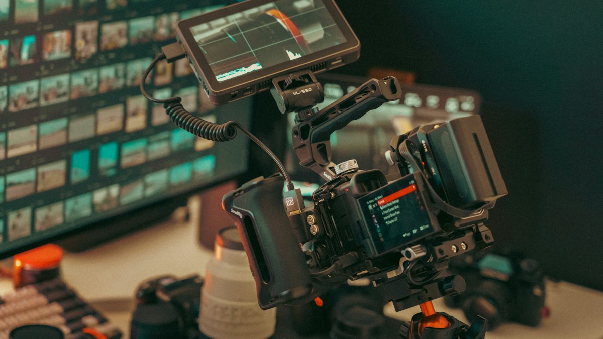 A professional camera rig with a monitor and lenses on a desk